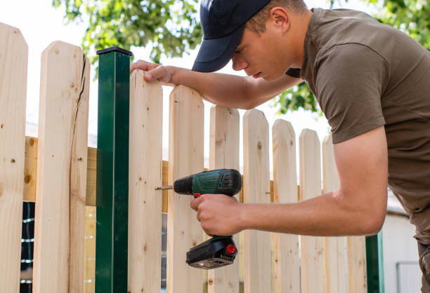 istock Young handsome man using electric drill on wooden fence 1152870356