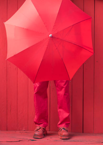 istock man in red clothes and red umbrella 1152870435