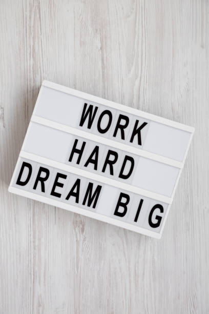 istock 'Work hard dream big' words on a lightbox on a white wooden background, top view. Flat lay, overhead, from above. 1152871068
