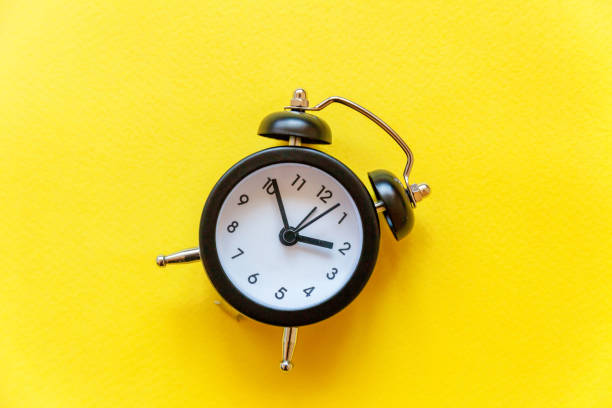 istock Vintage alarm clock Isolated on yellow background 1152871548