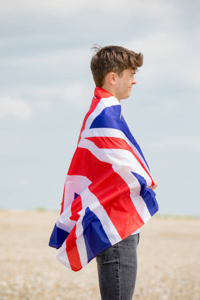 istock Caucasian male on a beach holding a British flag 1152874594