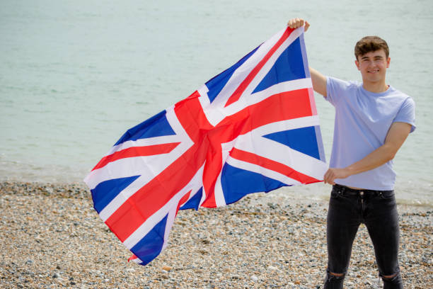 istock Caucasian male on a beach holding a British flag 1152874650