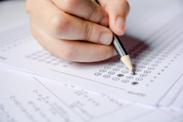 istock Students hand holding pencil writing selected choice on answer sheets and Mathematics question sheets. students testing doing examination. school exam 1152876538