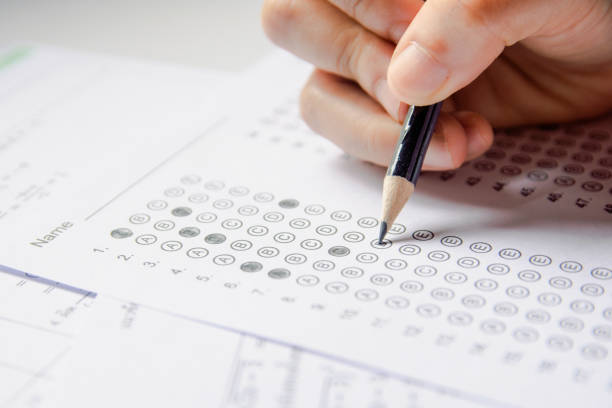 istock Students hand holding pencil writing selected choice on answer sheets and Mathematics question sheets. students testing doing examination. school exam 1152876748