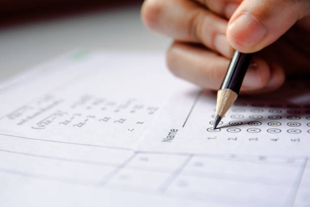 istock Students hand holding pencil writing selected choice on answer sheets and Mathematics question sheets. students testing doing examination. school exam 1152876778