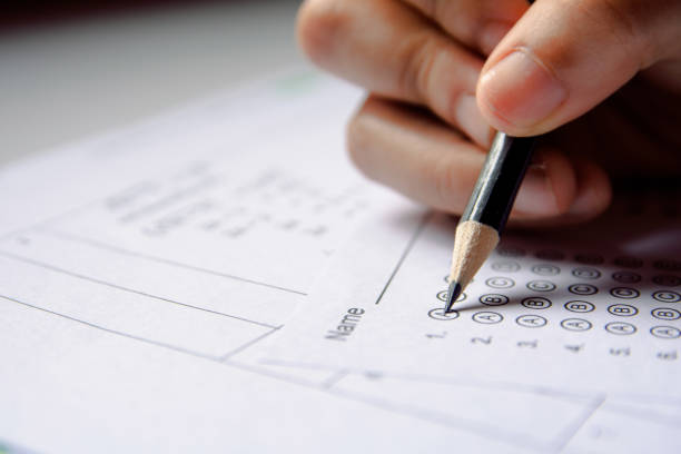 istock Students hand holding pencil writing selected choice on answer sheets and Mathematics question sheets. students testing doing examination. school exam 1152876938