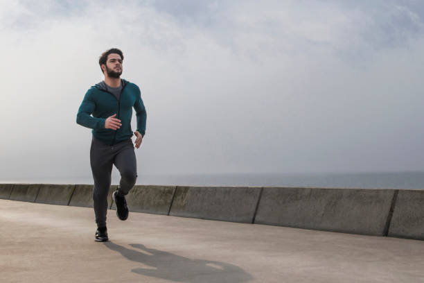 istock Active Young Man Jogging on A Foggy Winter Morning 1152877124