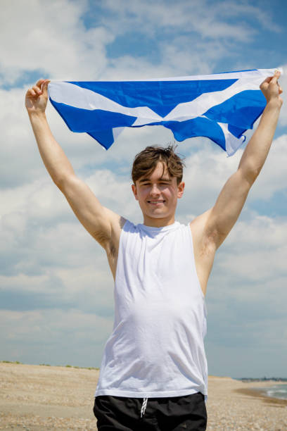 istock Caucasian male on a beach holding a Scottish flag 1152877777