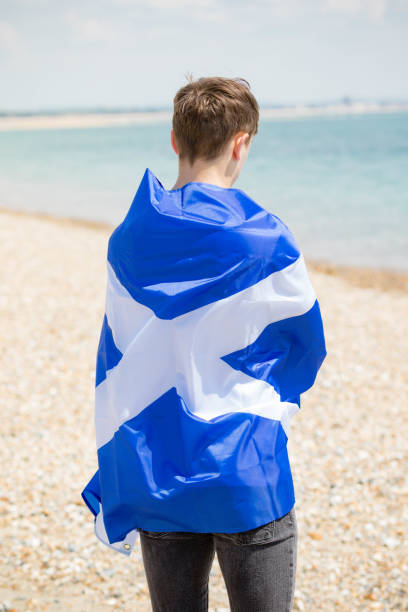 istock Caucasian male on a beach holding a Scottish flag 1152877847