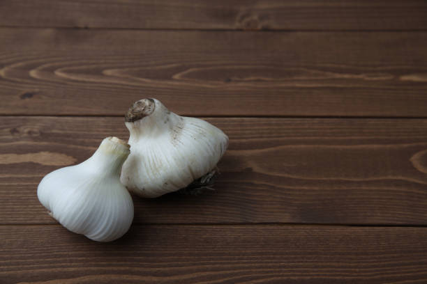 istock raw garlic isolated on wooden table 1152878011