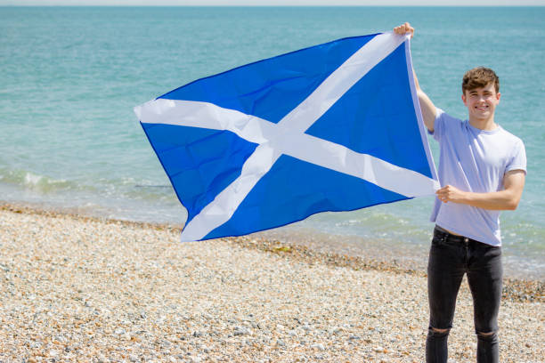 istock Caucasian male on a beach holding a Scottish flag 1152878193