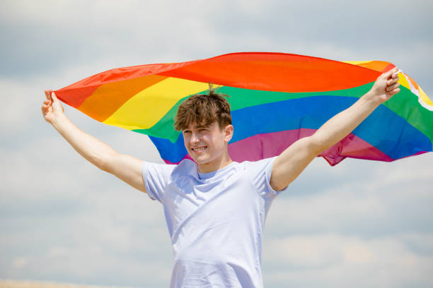 istock Caucasian male on a beach holding a Pride flag 1152878495