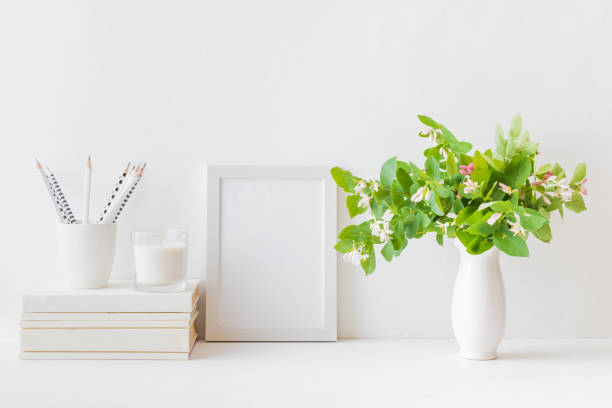 istock Home interior with decor elements. White frame, branches with green leaves in a vase, interior decoration 1152879441