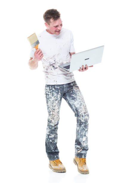 istock Very good looking young white painter on white background - holding laptop 1152880998