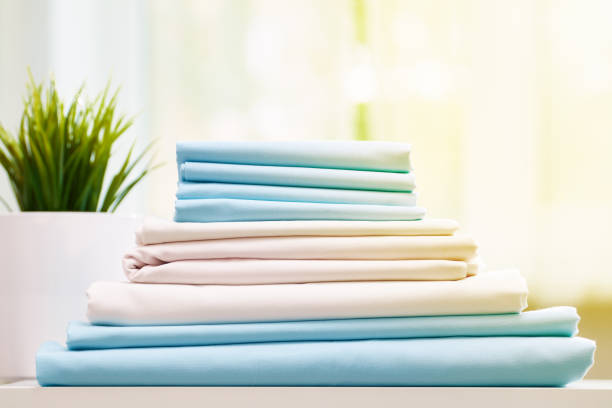 istock Closeup stack of blue and white clean bedding on the table. Blurred background. 1152881107