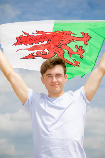 istock Caucasian male on a beach holding a Welsh flag 1152881447