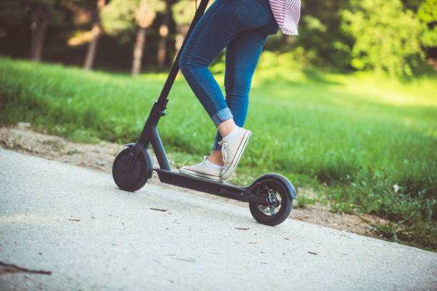 istock Woman riding motor scooter at park 1152881870