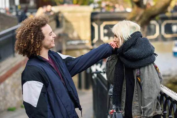 Photo of Young woman kissing the hand of her boyfriend in Camden Town Little Venice,