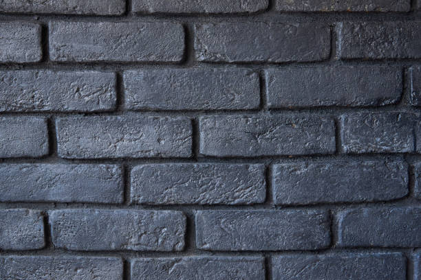 istock Fragment of a brick wall. The wall is painted black. Background 1152883365