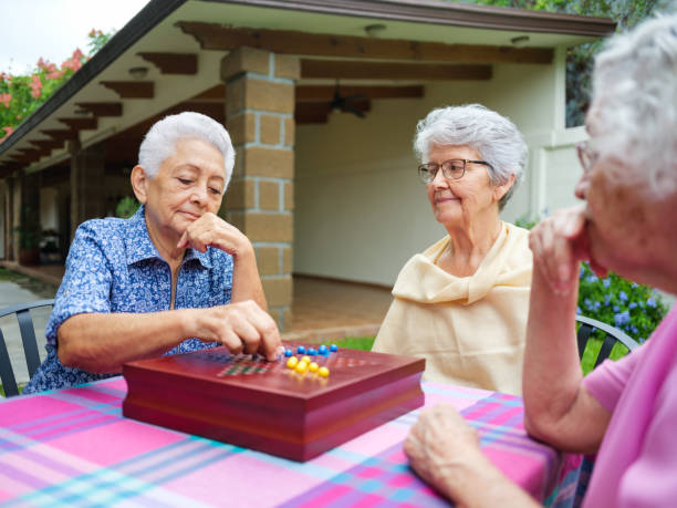 istock Lovely elderly women playing chinese checkers outside 1152884145