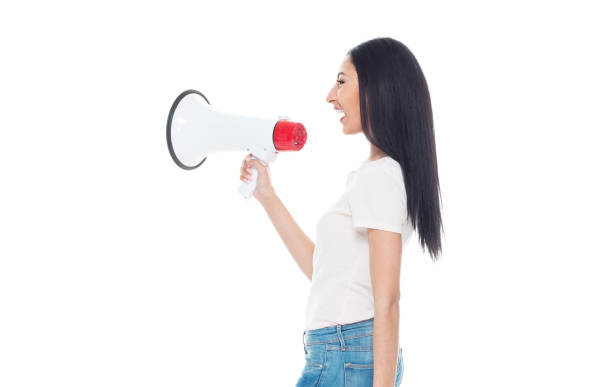 istock Beautiful young latino female wearing a tshirt and jeans - using a megaphone 1152884985