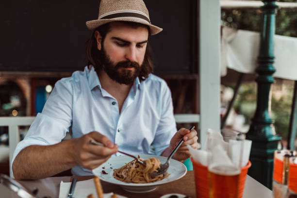 Handsome man enjoying a meal in the restaurant on a sunny day