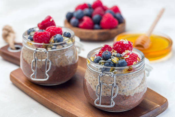 istock Layered chocolate and peanut butter chia seed pudding in jar, garnished with raspberry, blueberry, honey and coconut flakes, horizontal 1152893199