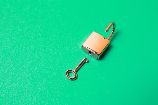 The top view shot of lock and key on a green background