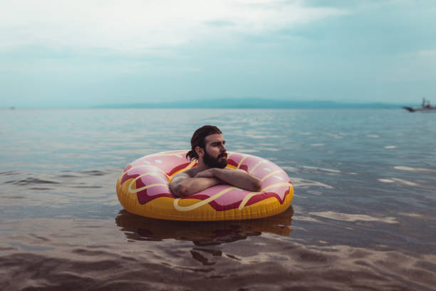 istock Man with an inflatable ring enjoying a day at the seaside 1152895169