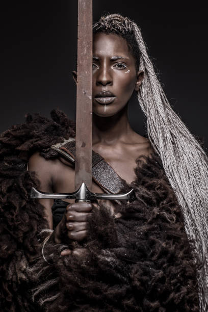 istock Beautiful black warrior princess holding a sword in studio shot 1152899209