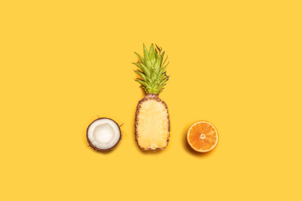 istock Creative summer composition of tropical fruit juices on a yellow background: oranges, coconuts, lemons, pineapples. 1152899241