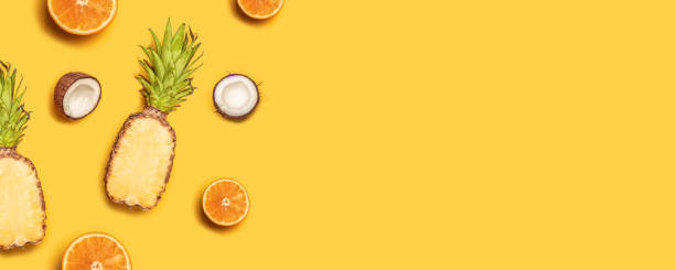 istock Creative summer composition of tropical fruit juices on a yellow background: oranges, coconuts, lemons, pineapples. 1152899246