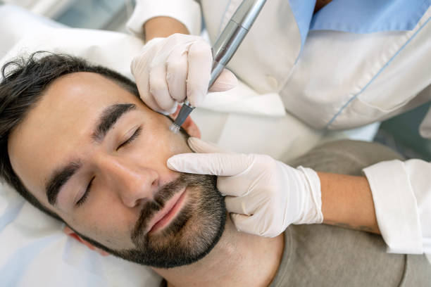 Young Man in Beauty Clincic Having Dermatude Meta Therapy, Rejuvenating Treatment,  by Cosmetologist stock photo