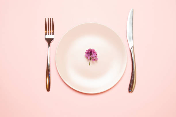 istock Pink empty plate with fork and knife on a pink tablecloth 1152900447