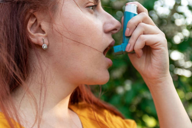 istock Medical concept. Young woman using asthma inhaler 1152900938