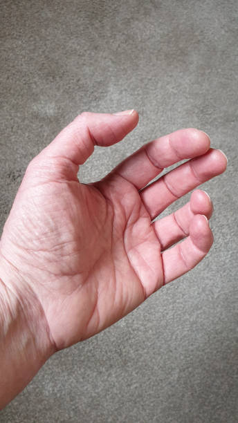 istock Close up of hand on grey textured background with copy space 1152901676