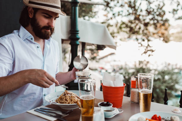 istock Young man eating spaghetti on the restaurant balcony 1152901890
