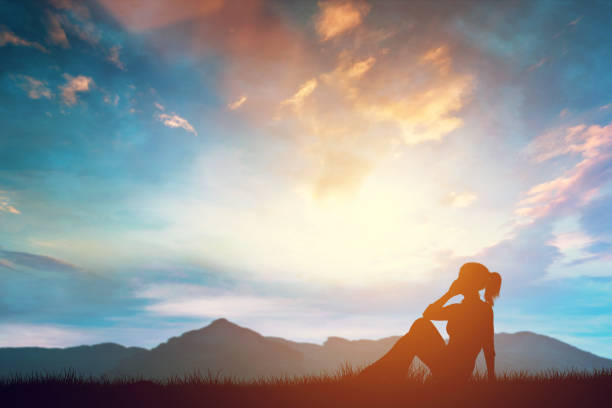 istock Woman talking on phone while relaxing outdoors at sunset. 1152902544