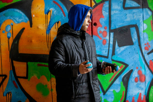 istock Young Adult Graffiti Artist Shaking Spray Cans 1152902893