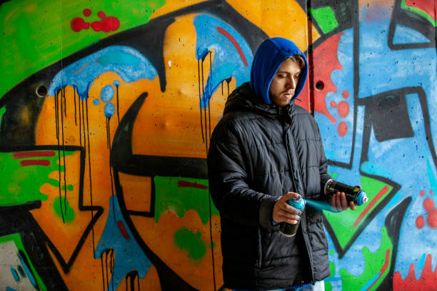 istock Young Adult Graffiti Artist Shaking Spray Cans 1152902903