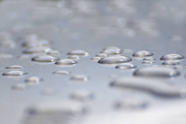 gouttes de pluie perles sur une surface argentée close up abstrait - beaded water photos et images de collection