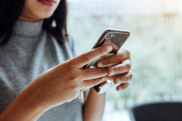 istock status update, woman holding phone 1152909657