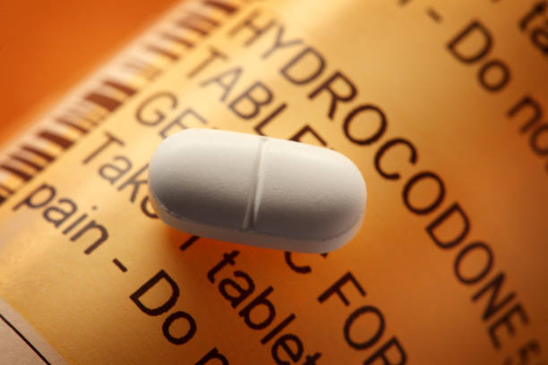 opioid pill on a hydrocodone prescription pill bottle - hydrocodone imagens e fotografias de stock