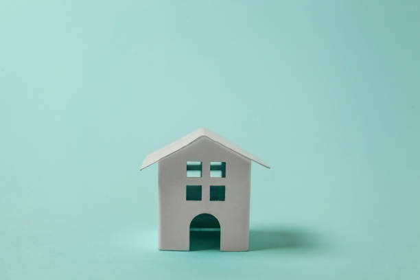 istock Miniature white toy house on blue background 1152917894