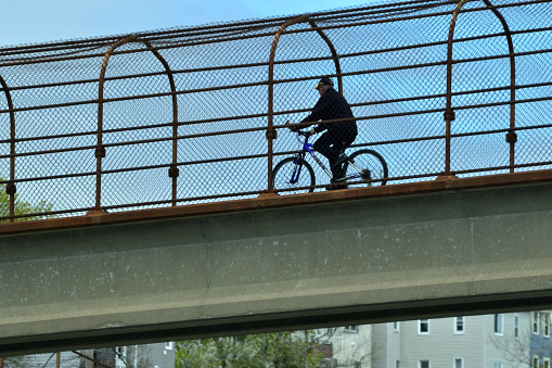 Saint John, New Brunswick / Canada - May 30 2019:  Man Riding a Bicycle in an Overhead Highway Pedway