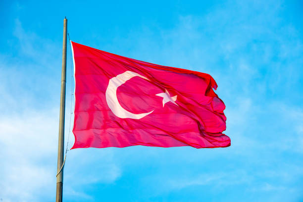 istock Turkey flag waving in blue cloud sky 1152919778