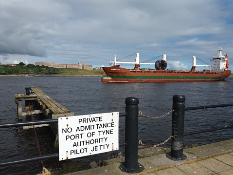 Merchant vessel passing old Pilot Jetty River Tyne at South Shields
