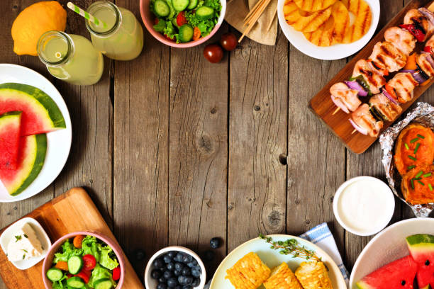 istock Summer BBQ or picnic food frame, top view over a wood background 1152924903