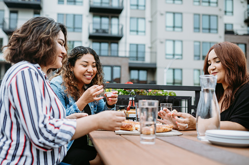 Three Hispanic women enjoy coffee at a cafe diner, having fun sharing life experiences and memories. 
 Shot in Tacoma, Washington.