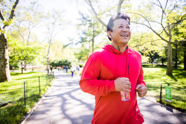 reifer hispanics jogging im central park - sports clothing jogging running 40s stock-fotos und bilder